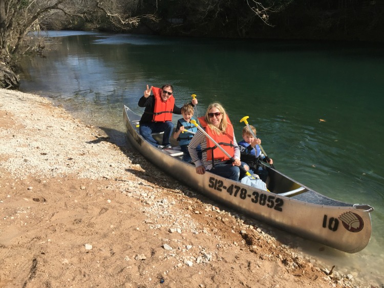 a family sits inside a canoe